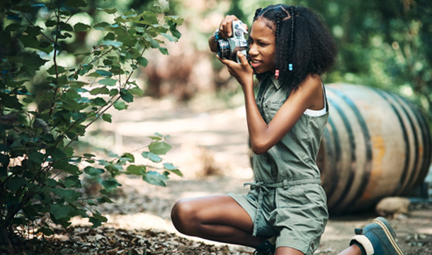 girl scout taking a photo of a plant