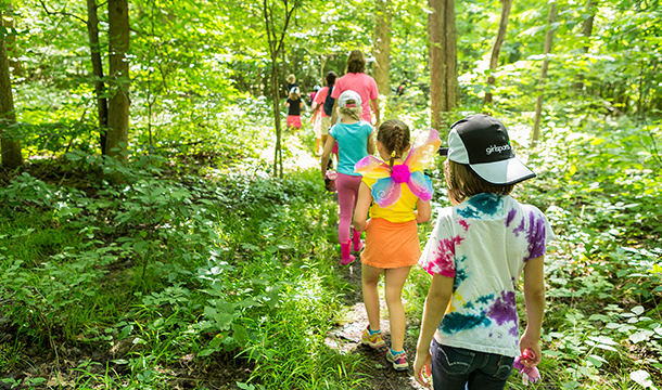 girl scouts walking in the woods