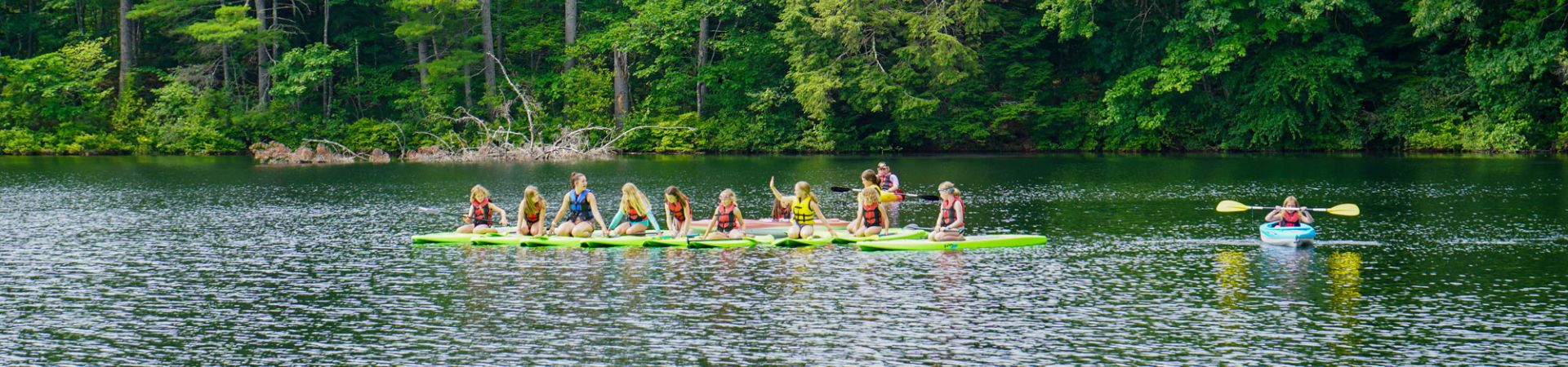  group of girl scouts on paddleboards in the water 