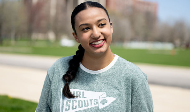 Smiling older Girl Scout outside wearing a Girl Scouts shirt