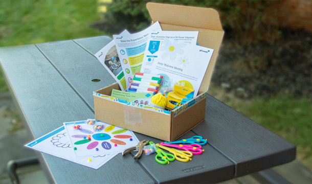 Girl Scout Experience Box open on a picnic table outside
