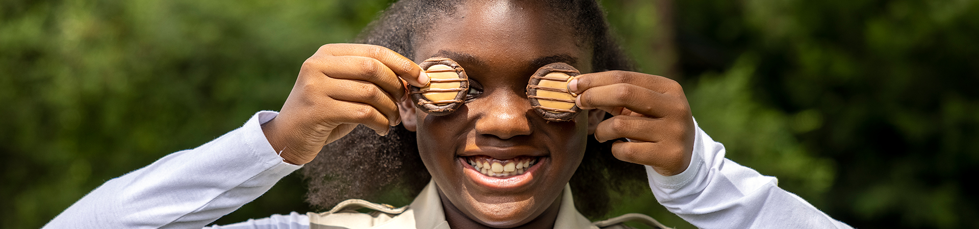  Gril holding Adventurefuls cookies over her eyes 