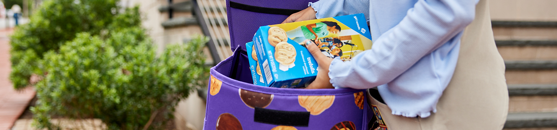  Girl scout Cookies being placed into a cookie cart 
