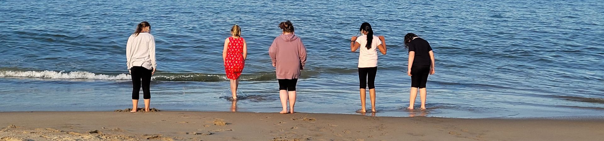  Girls from troop 60 standing near the ocean to make candles in the sand 