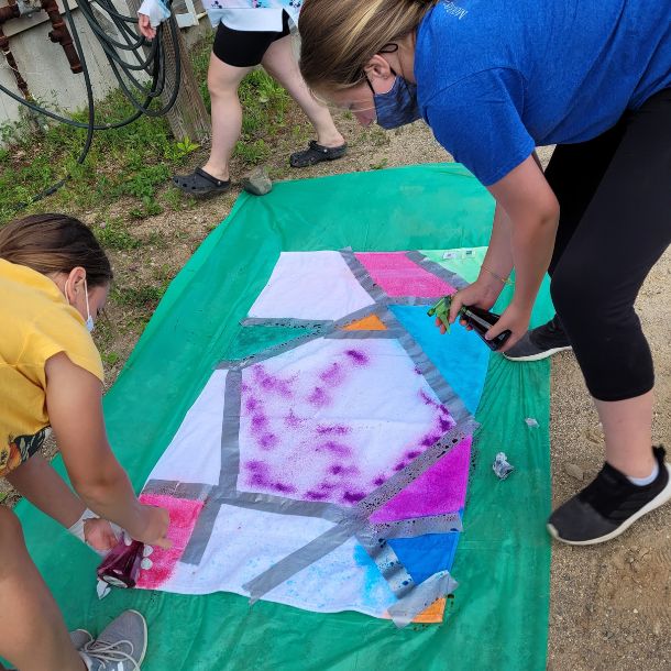 Girl and adult tie-dying a towel