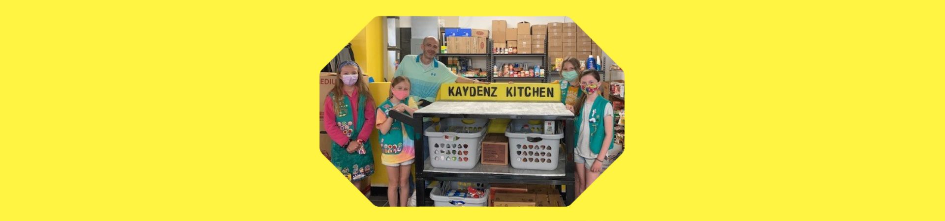  Girls from troop 507 standing next to the cart they built for Kaydenz Kitchen Food Pantry 