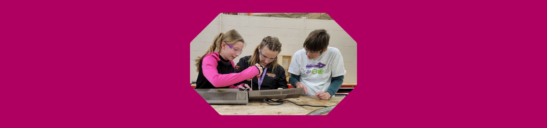  girls working on taking apart an object 