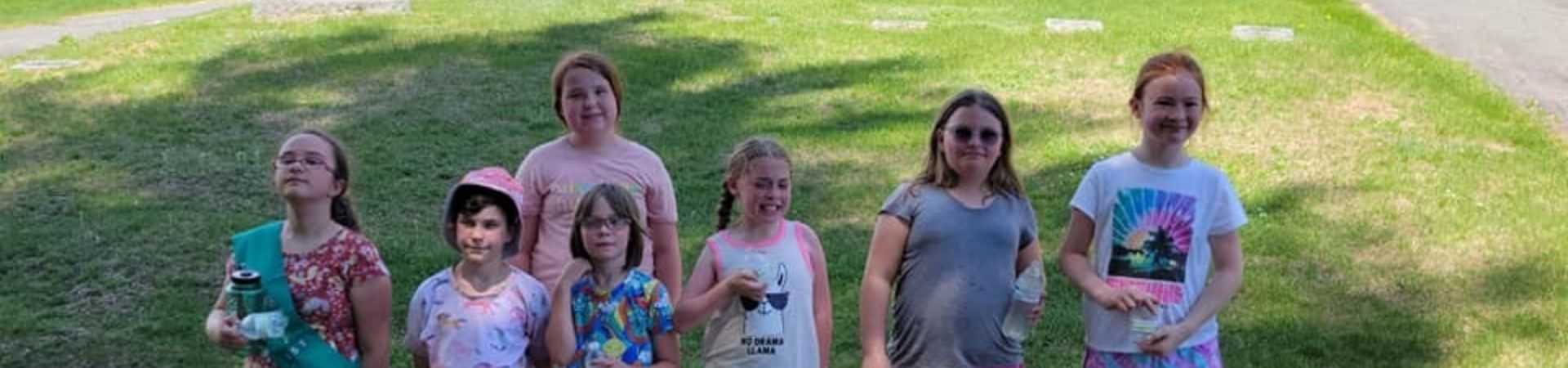  Girl Scouts from the Somerset Service Unit standing in front of Veterans headstones 