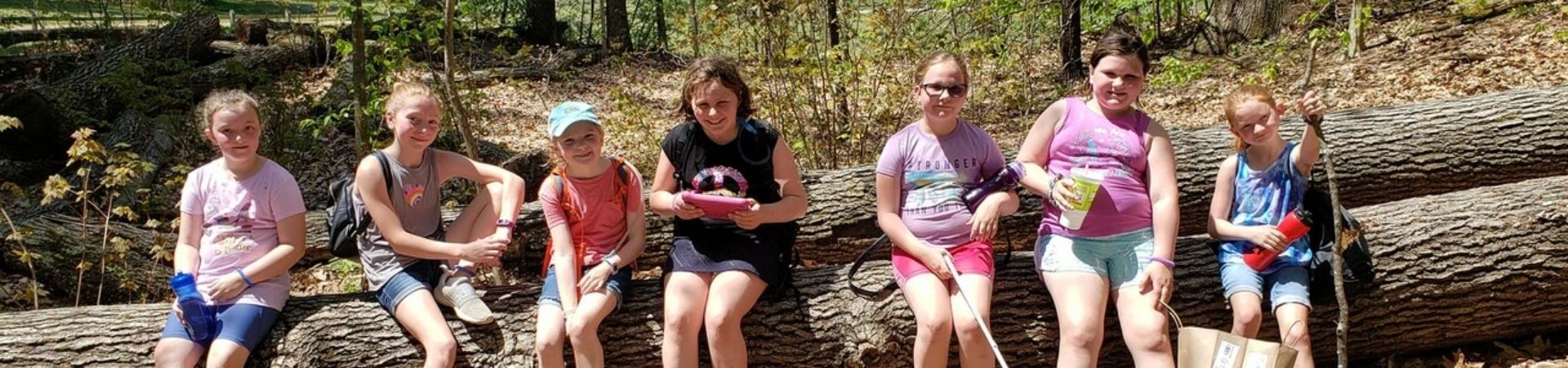  Troop 115 sitting on a log in the woods 