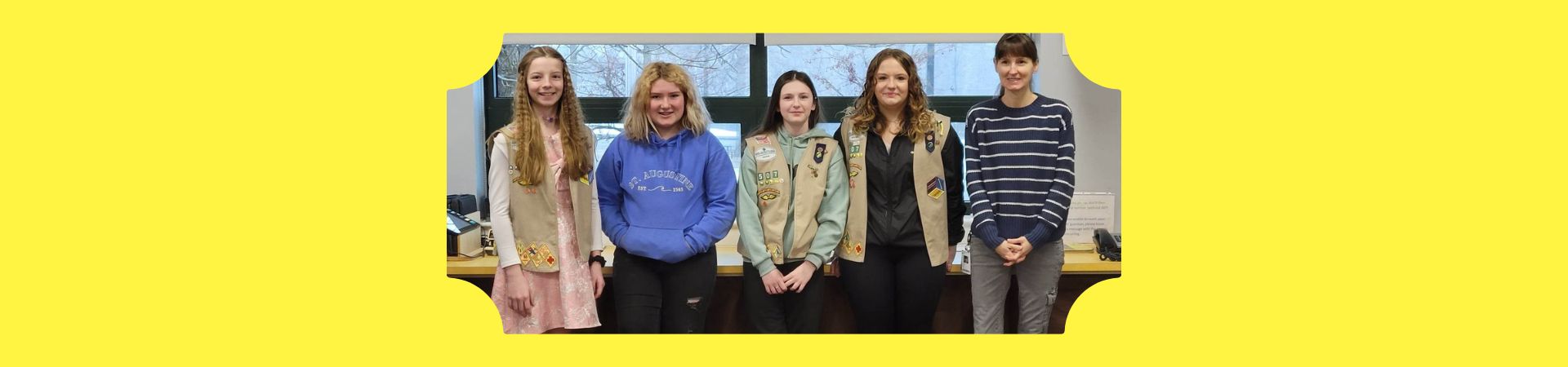  Four Girl Scouts standing in the school office with the adminitartive assistant 