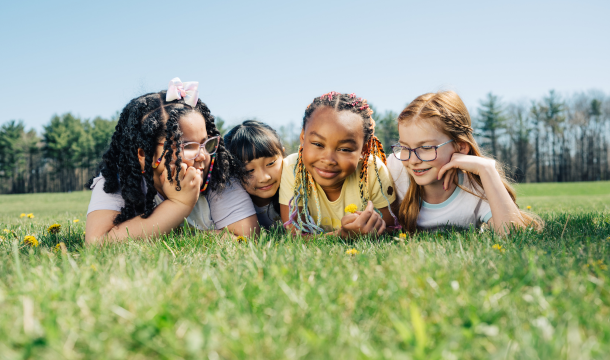group of girl scouts laying in the grass