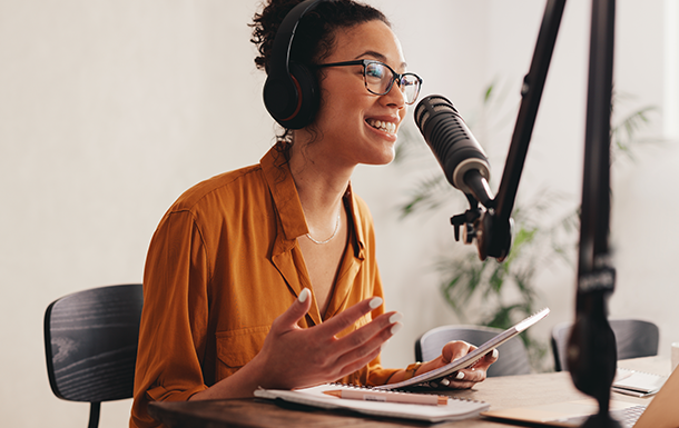 Woman wearing headphones and speaking into a mic