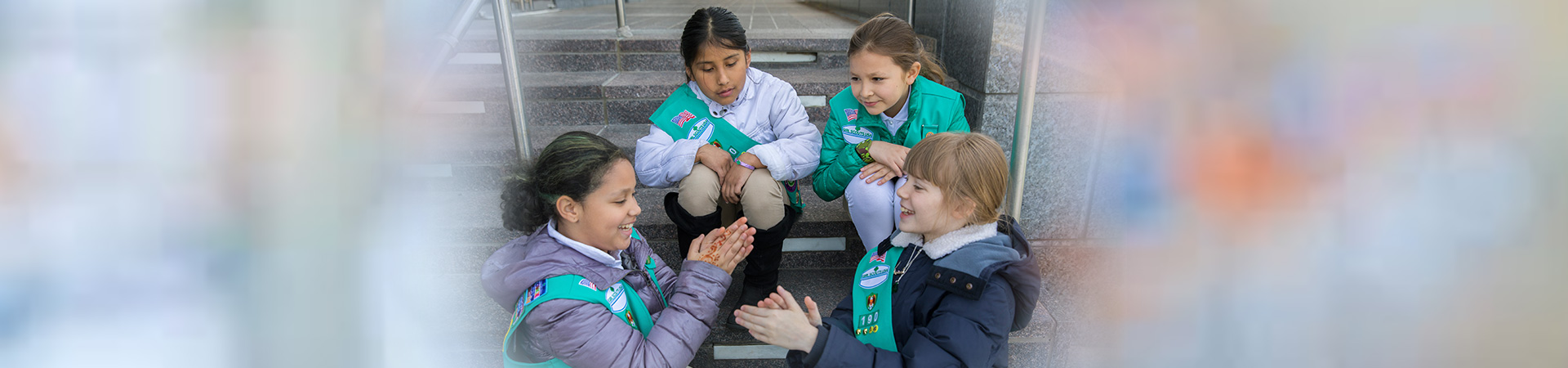  Junior Girl Scouts sitting together on steps outside 