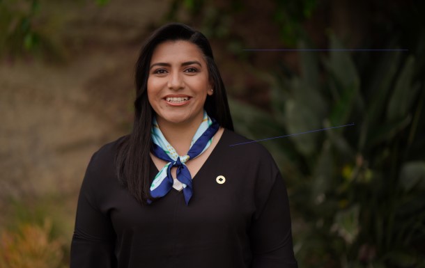 Woman smiling and wearing a Girl Scout scarf and pin