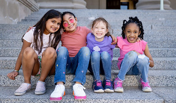 group of girl scouts sitting on steps outside