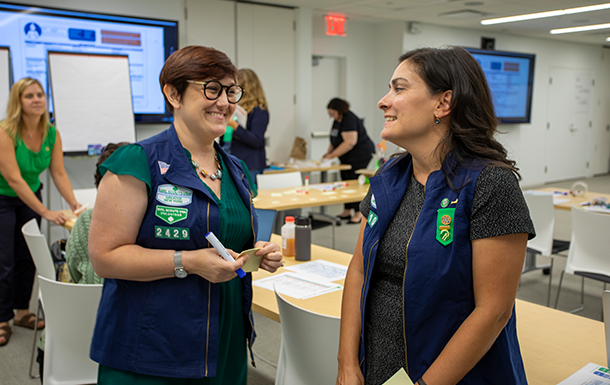 Two Girl Scout volunteers talking in a room