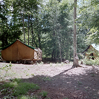 view of tent in the woods at camp kirkwold