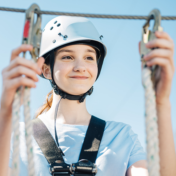 a girl in a helmet getting ready to zipline