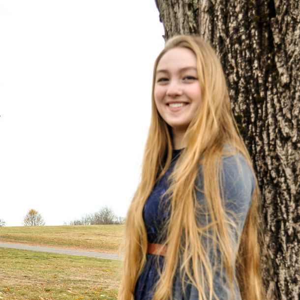 Picture of Grace leaning back on a tree and smiling