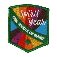Girl Scout Spirit Year patch with a variety of colors and a green sash across the front that says Girl Scouts of Maine with a trefoil underneath