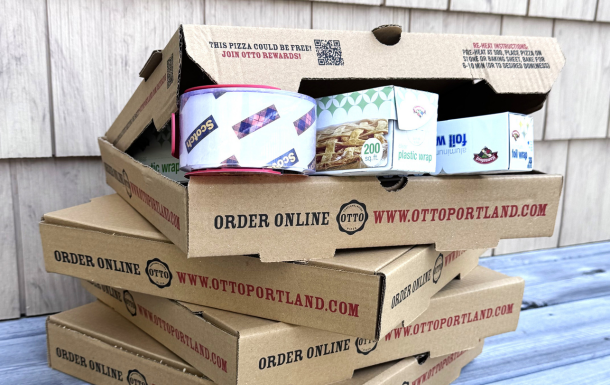 stack pizza boxes with tape, plastic wrap, and foil popping out of the top box