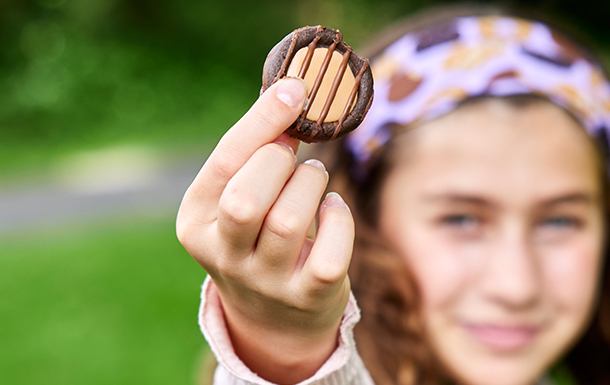 Girl Scout holding up an Adventurefuls cookie